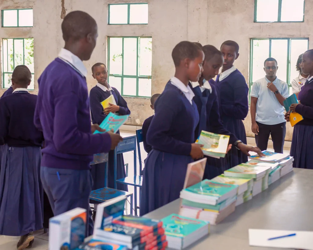 Students wait in line to receive their new textbooks at the table