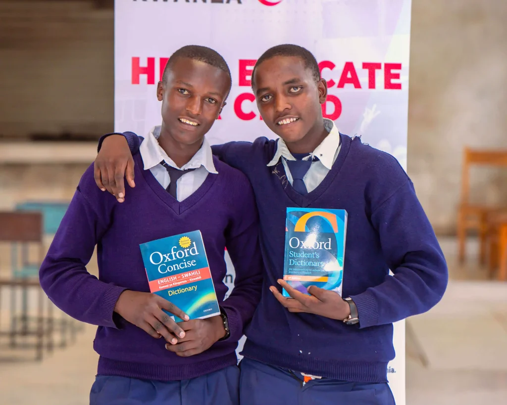 two students smiling and holding their new textbook