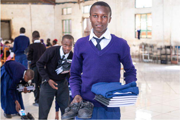 young students holding his new school uniform, shoes and supplies