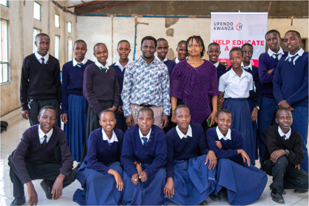 A group of Kisimiri students smiling and taking picture with Upendo Kwanza board member